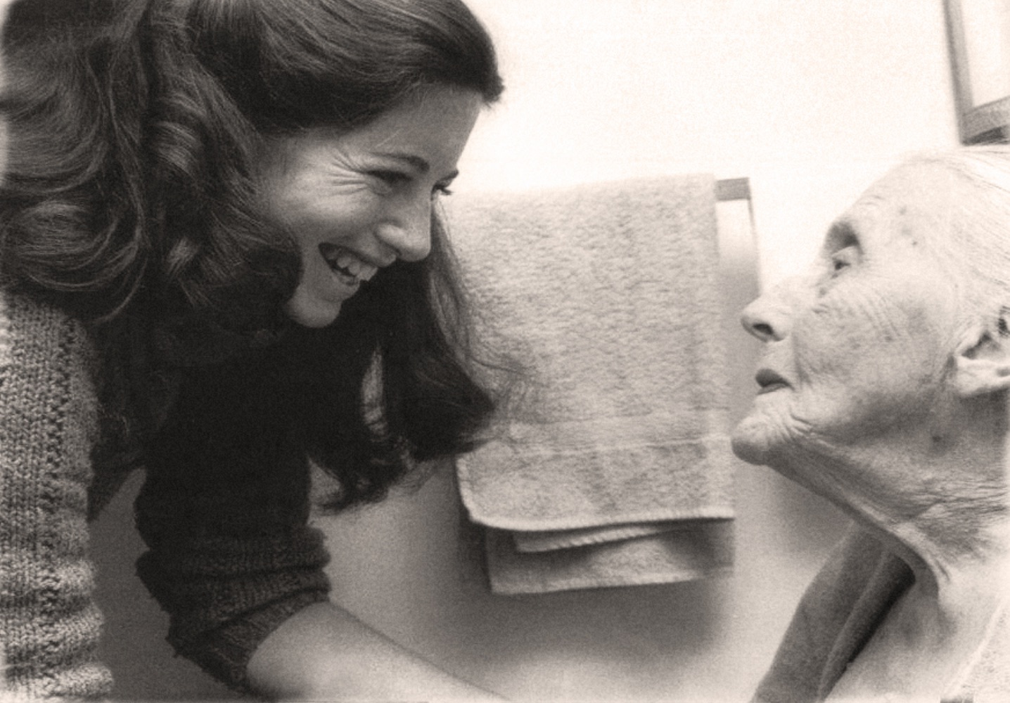 Photo of a careworker smiling at an elderly patient.